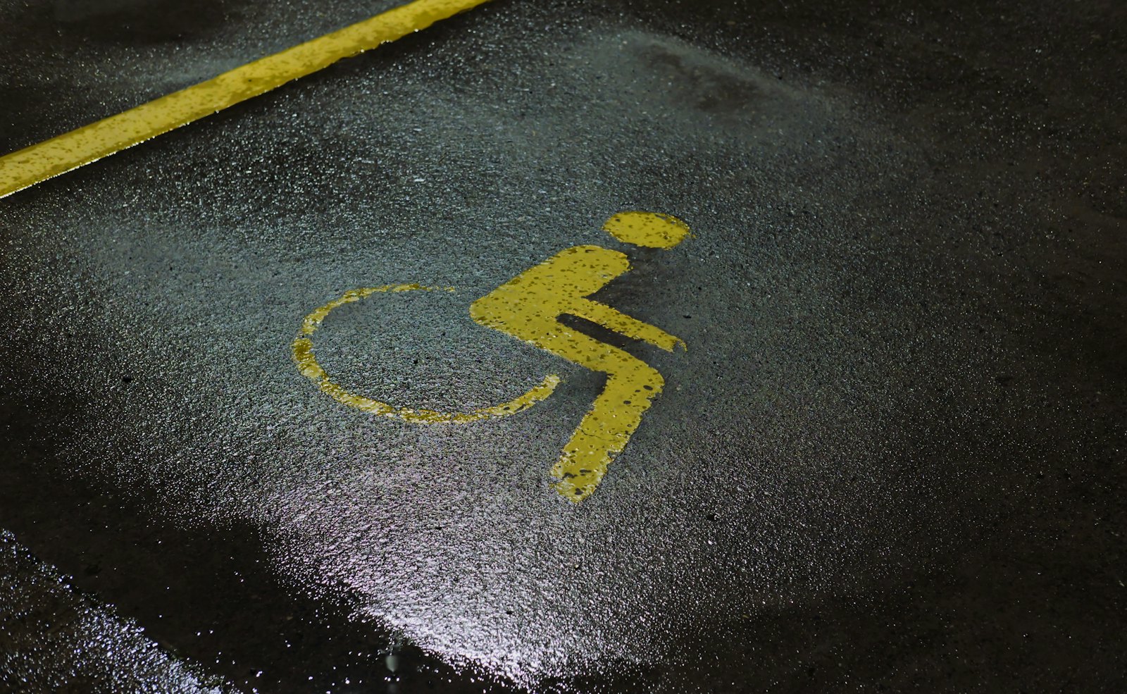 Accessible parking symbol stenciled on pavement
